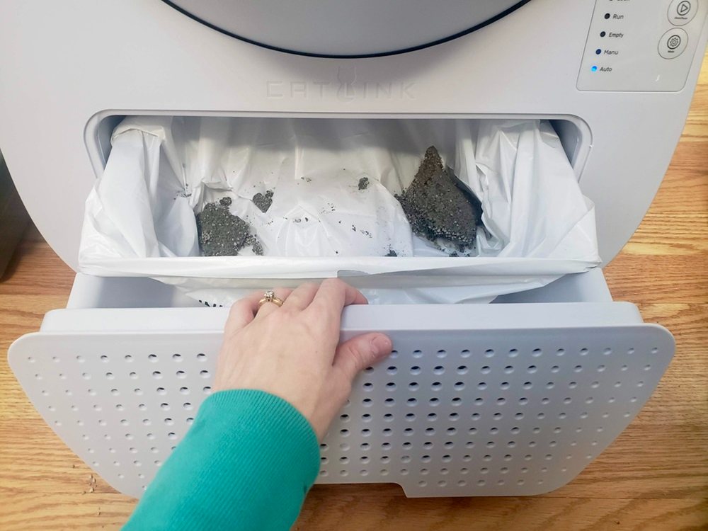 opened waste drawer with litter clumps inside